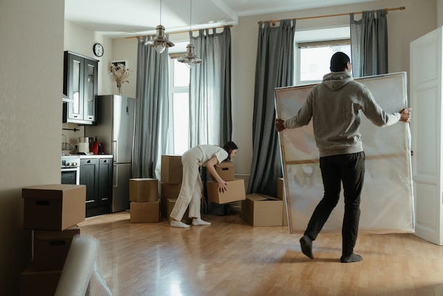 a%20couple%20moving%20into%20a%20new%20home%20carrying%20boxes%20and%20artwork a%20couple%20moving%20into%20a%20new%20home%20carrying%20boxes%20and%20artwork